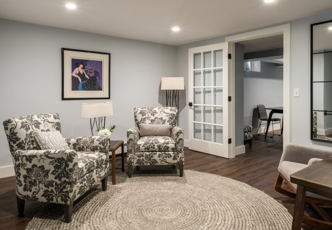 Finished basement sitting area with seating area and updated finishes (JM Construction)