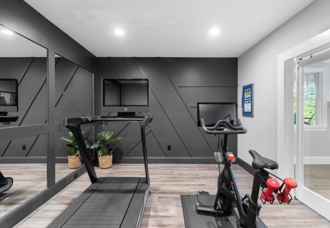 Finished basement workout area with mirrors and updated wall finishes (JM Construction)