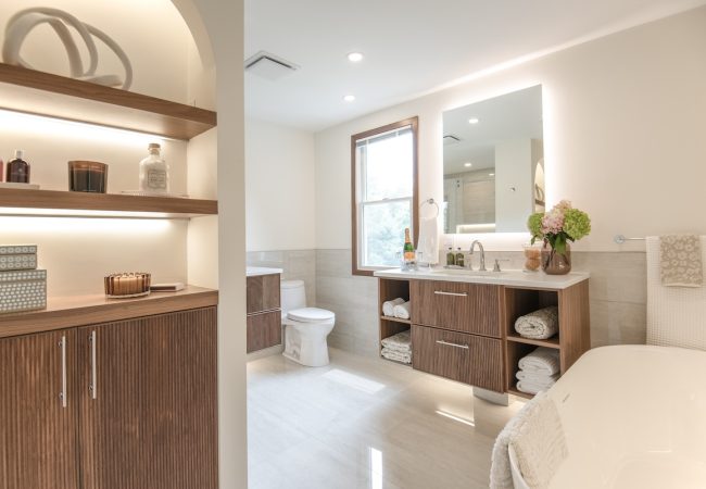 Updated bathroom with freestanding tub, wood finishes, vanity, and toilet (JM Construction)