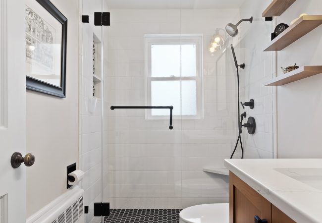 Updated bathroom with walk-in shower and black-and-white custom tile (JM Construction)