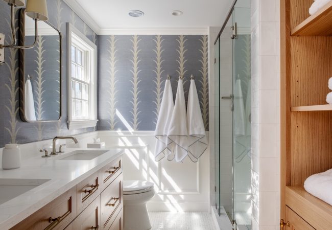 Updated bathroom with double vanity, walk-in shower, and built-in shelves (JM Construction)