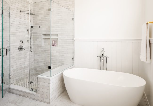 Updated bathroom with walk-in shower, freestanding tub, and new tile throughout (JM Construction)