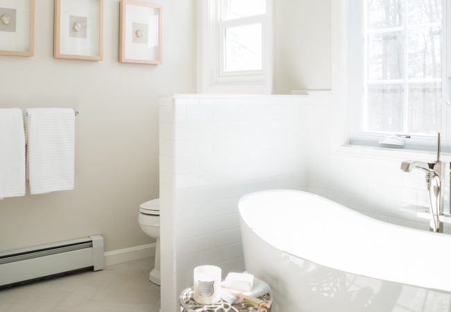 Bathroom with freestanding tub, toilet divider, and large windows for natural light (JM Construction)