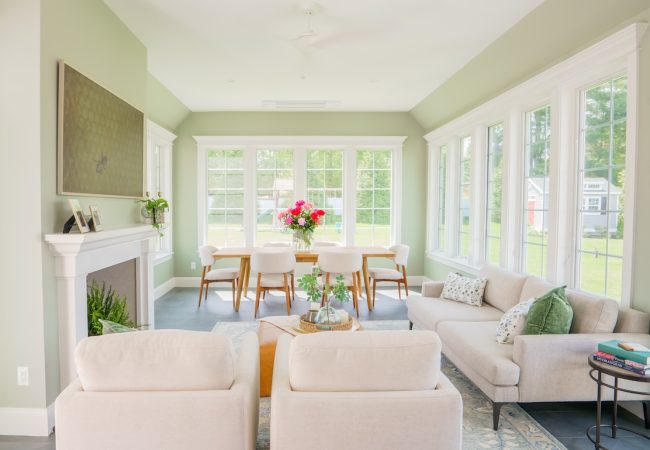 Home addition sitting room with fireplace, large windows, and space for dining table (JM Construction)