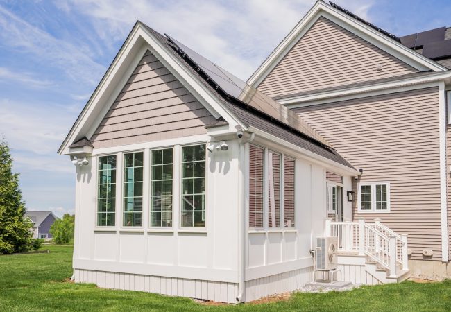Exterior view of new home addition with entry stairs, large windows, and custom finishes (JM Construction)