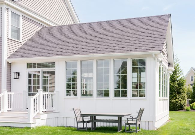 Exterior home addition with entry stairs, large windows, and sliding glass door to backyard (JM Construction)