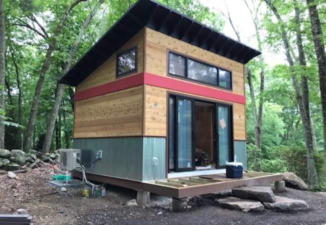 ADU under construction with raised deck, sliding glass doors, and exterior AC unit (JM Construction)