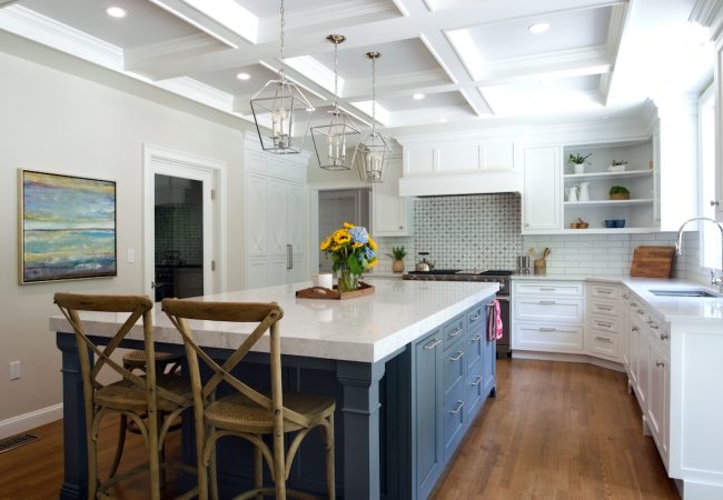 Updated kitchen with large sit-down island, built-in drawers, custom tile backsplash, and wood floors (JM Construction)