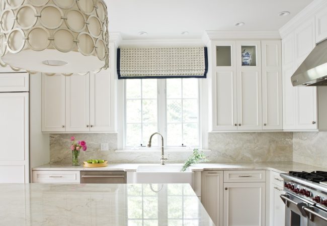 Refreshed kitchen with farmhouse sink, island, range and hood, window above sink, and built-in cabinets (JM Construction)