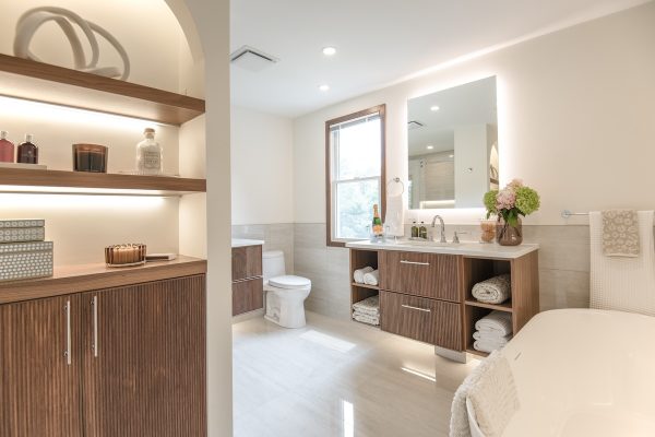 Updated bathroom with freestanding tub, wood finishes, vanity, and toilet (JM Construction)