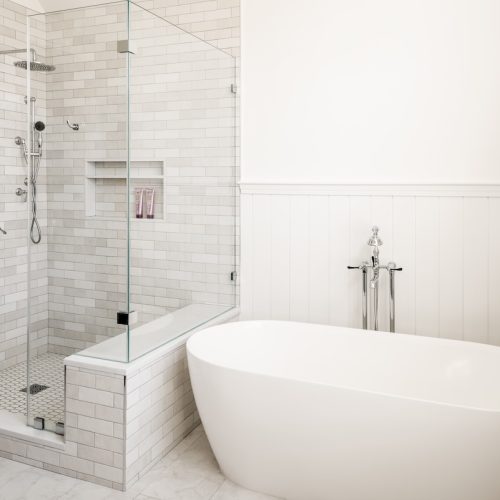 Updated bathroom with walk-in shower, freestanding tub, and new tile throughout (JM Construction)